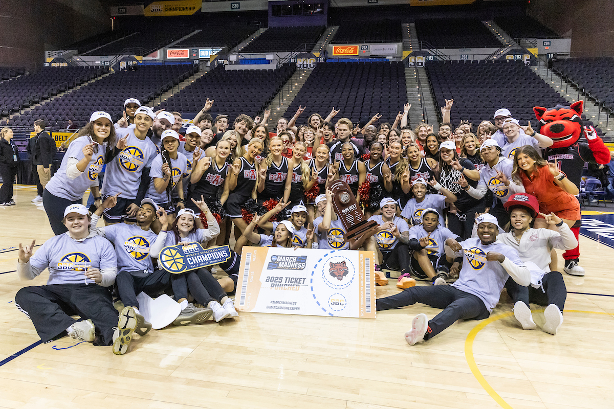 The A-State Women’s Basketball team celebrates a conference championship with members of the spirit squads and band.