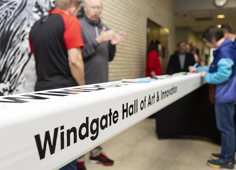 Students signing a beam that will be put in the future Windgate Hall of Art and Innovation