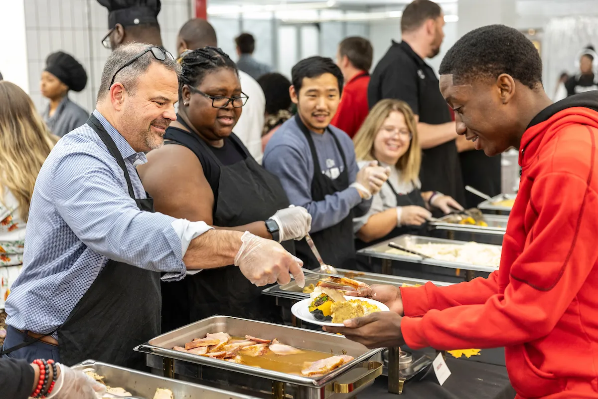 Chancellor Todd Shields helps serve Thanksgiving dinner in the Acansa Dining Hall