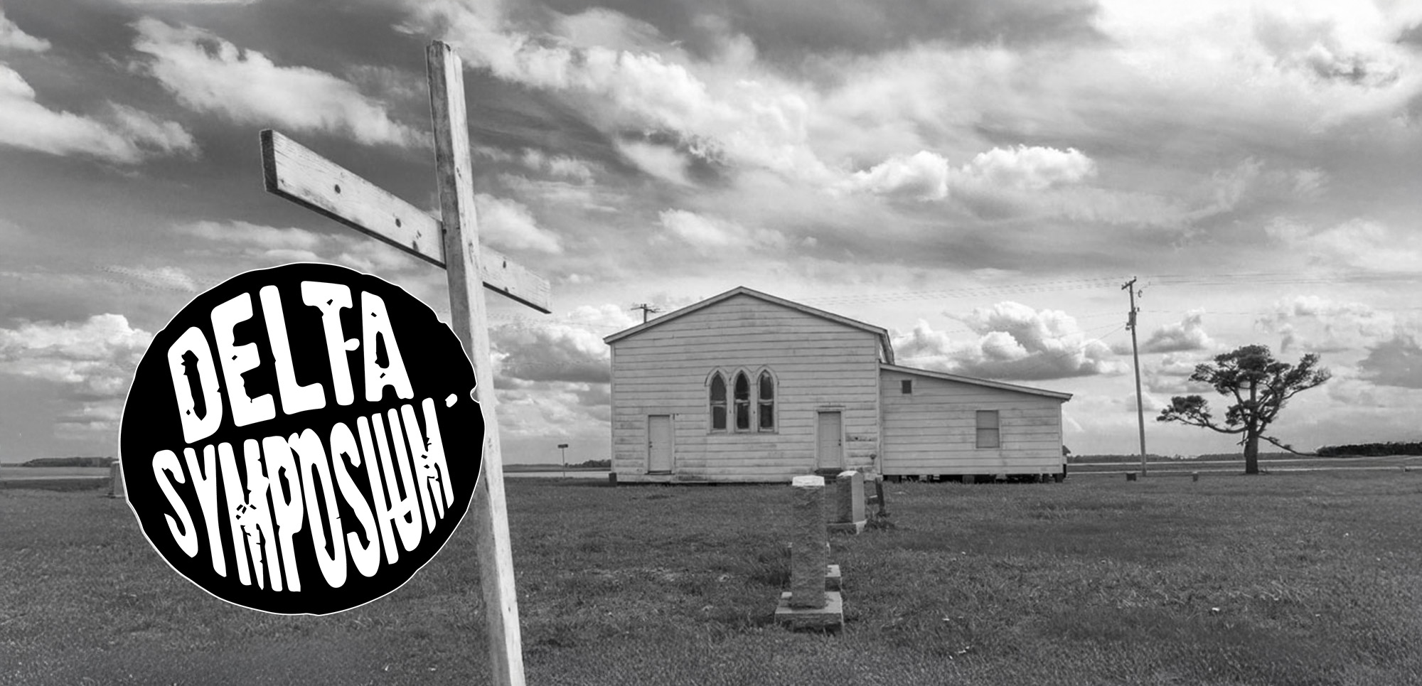 black and white image of small white house in a field with the Delta Symposium logo in the foreground