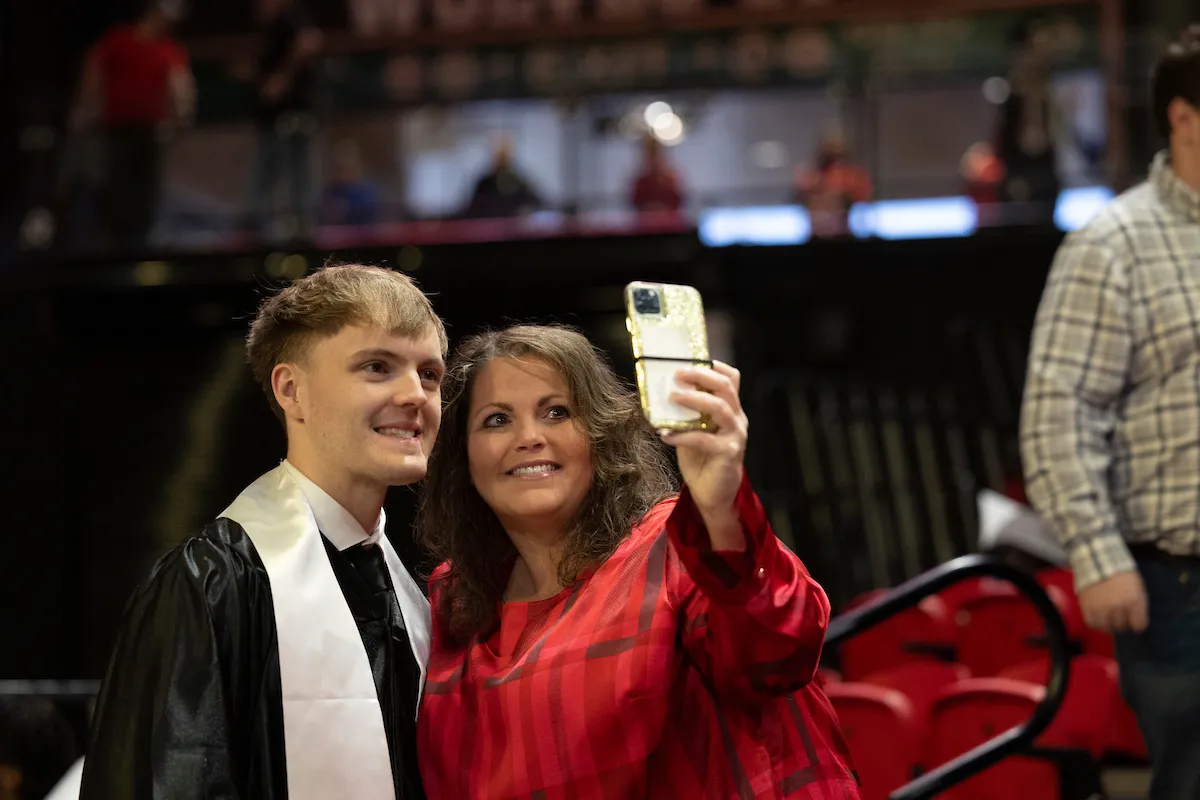 A mom takes a selfie with her son who is graduating from A-State.