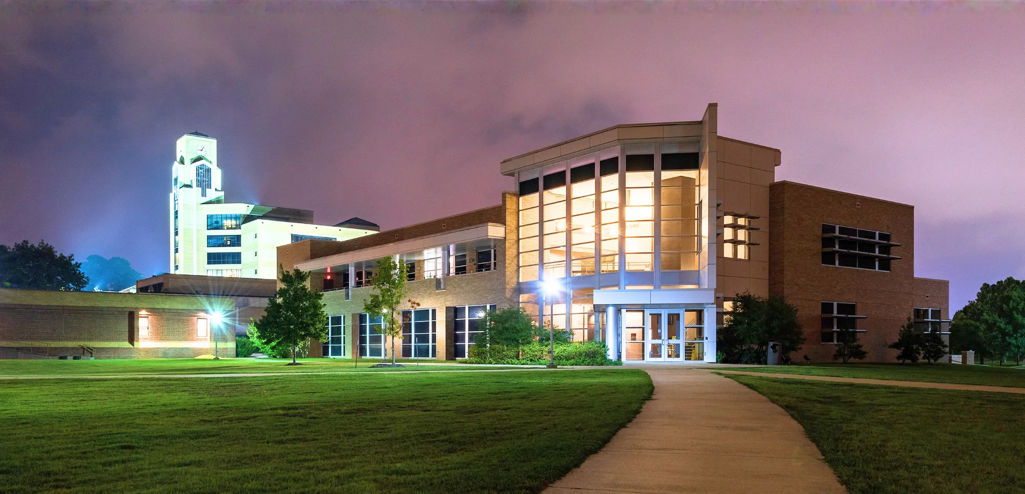Delta Center for Economic Development at night with a sky-blue-pink background.