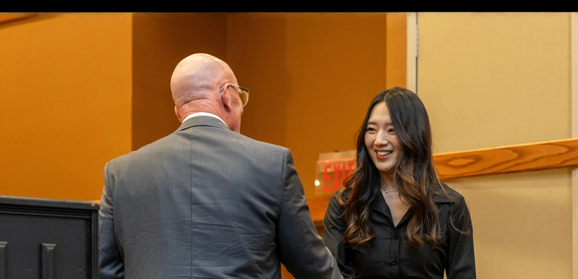 Dr. Doering shaking hands with a student at an awards ceramony.