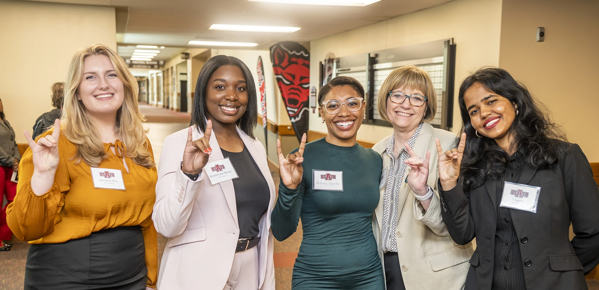 Center for Leadership Excellence members giving Wolves Up in business attire.