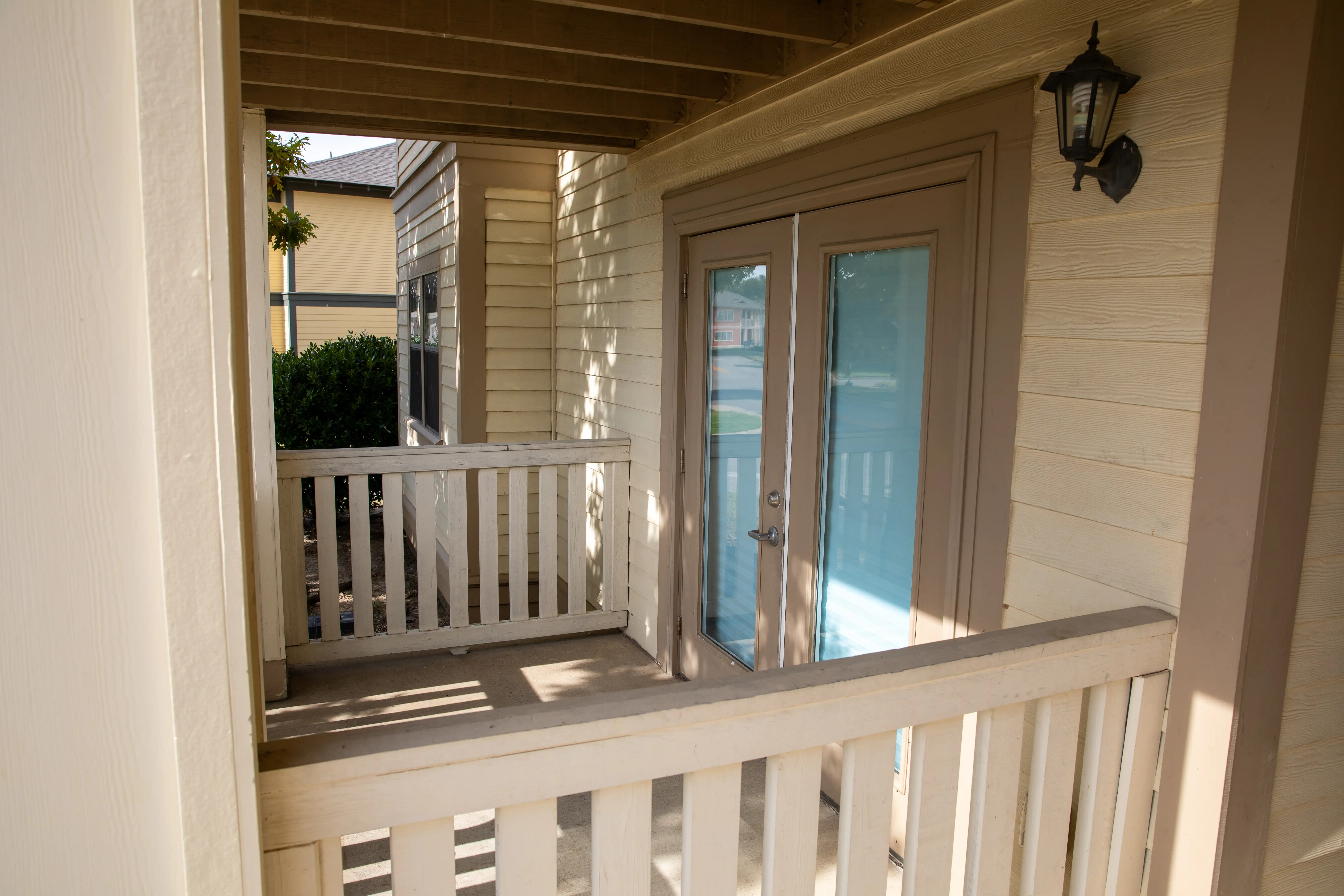 Covered porch, surrounded by railing.