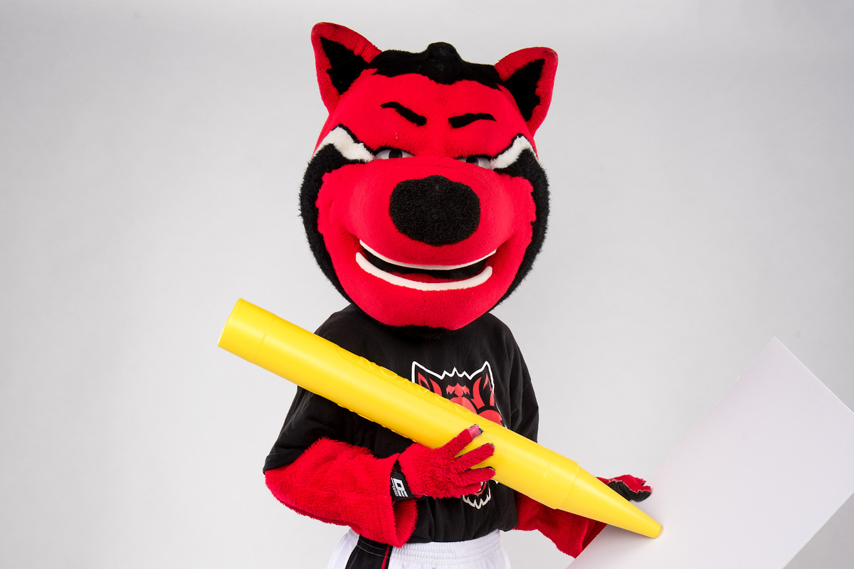 HOWL, A-State’s mascot, holding a giant pencil and blank, giant sheet of paper.