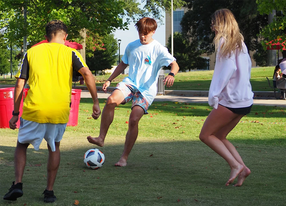 students playing soccer on the lawn