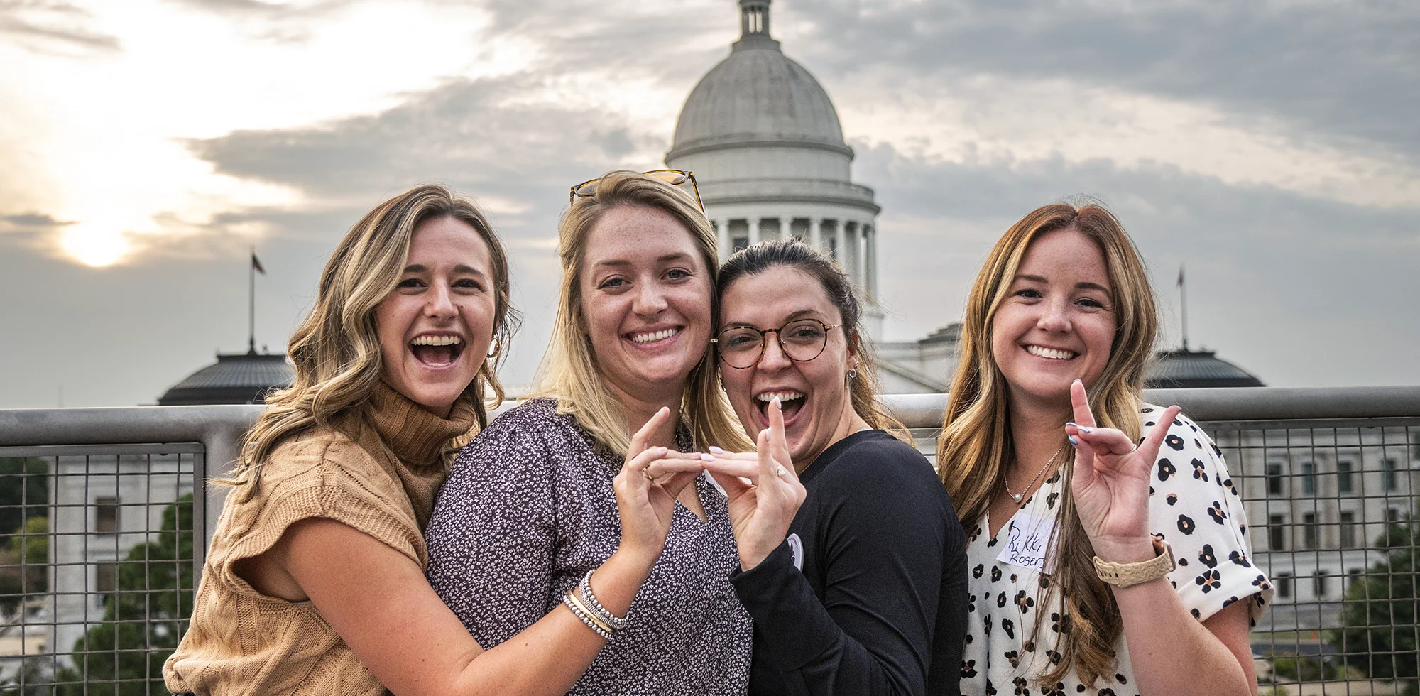 Students giving a Wolves Up in front of the capitol building in Little Rock.