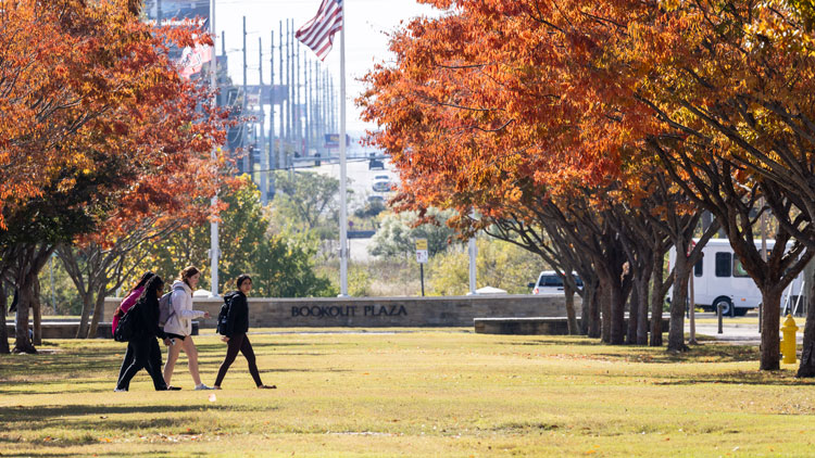 Photo of campus with traffic behind them.