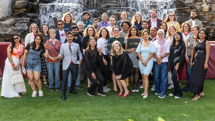 Group of people in front of a waterfall 