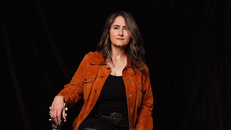 Photo of a woman holding a guitar