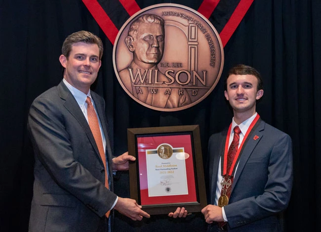 Reed Middleton (right) of Marianna accepts the 2022 Wilson Award from Perry Wilson, great-great-grandson of R.E. Lee Wilson, for whom Arkansas State University's highest award for a graduating student is named.