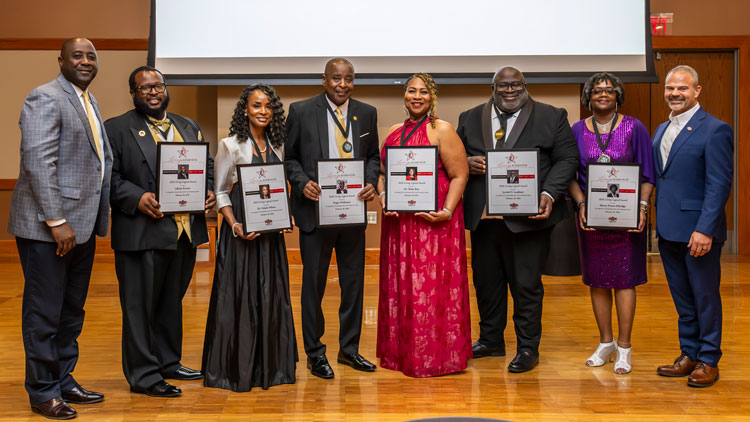 Individuals standing with awards