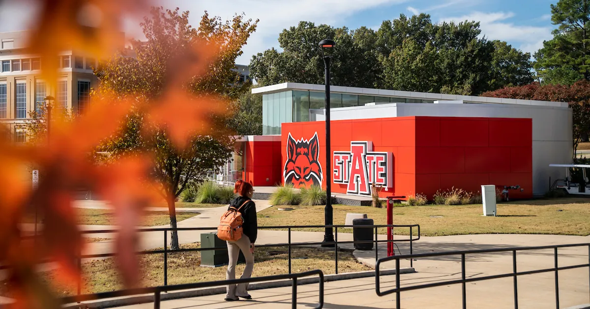 A student walks down a path near the Welcome Center