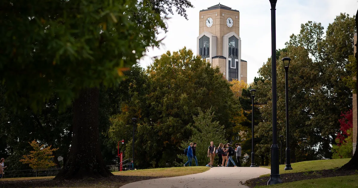 Students walk down path in front of the Dean B. Ellis Library.