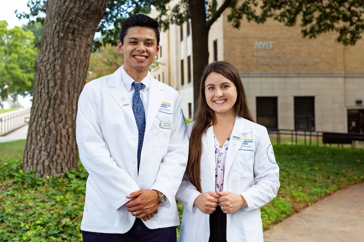 Doctor of Osteopathic Medicine students pose in front of Wilson Hall, home of the NYIT College of Osteopathic Medicine at A-State
