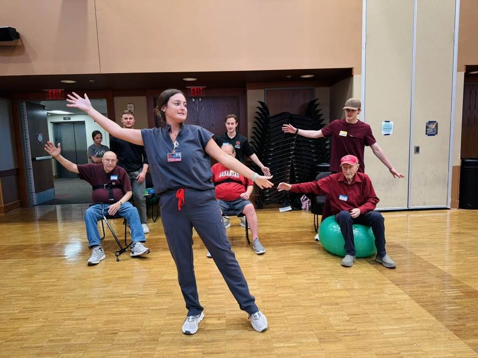 Occupational therapy class working with seniors in gym.