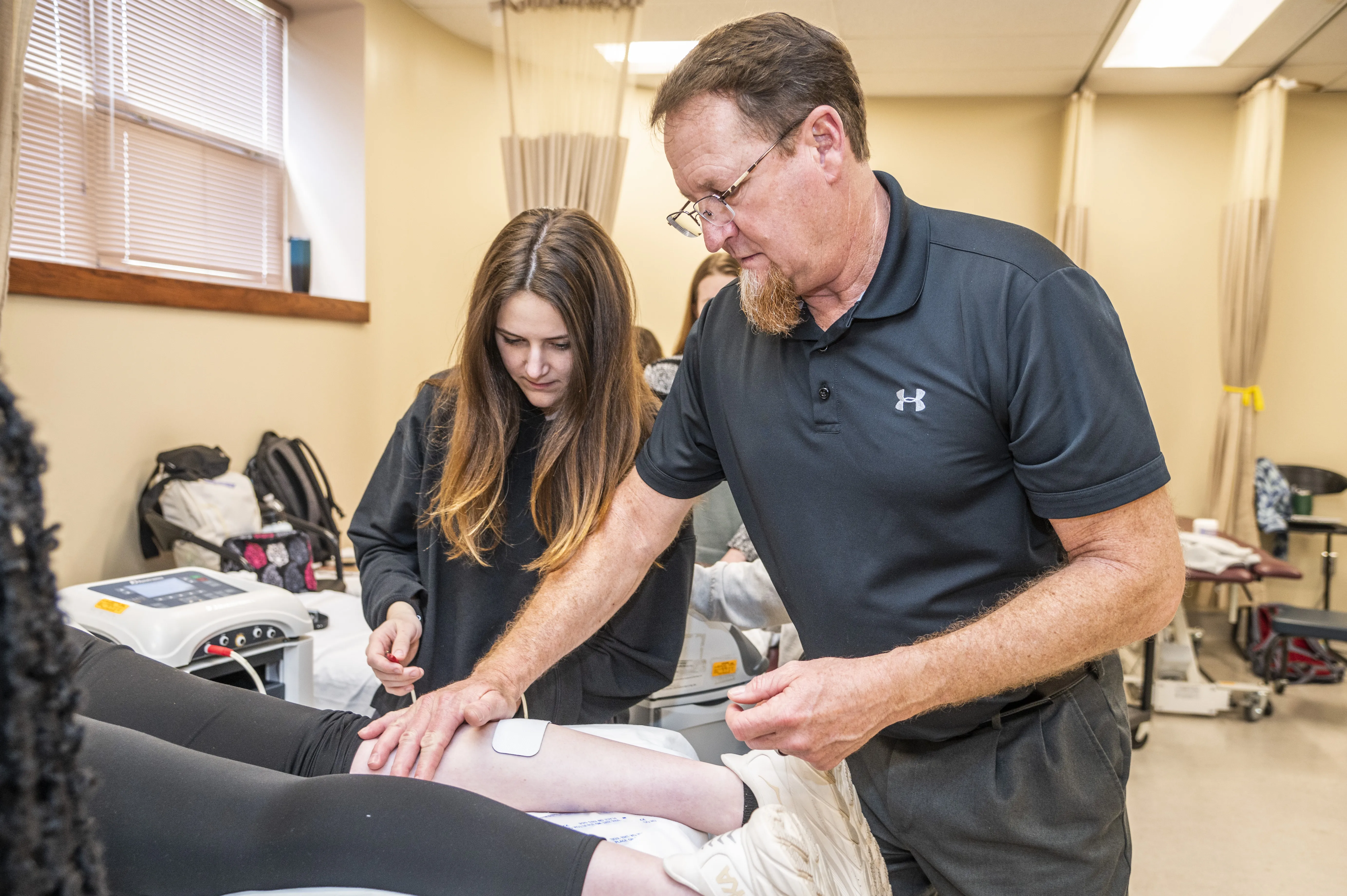 Physical therapy students in class doing practices with Dr. Farris. 