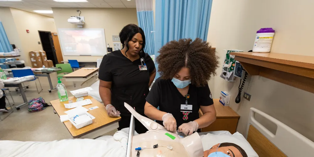 Nursing students practicing in class on dummies.