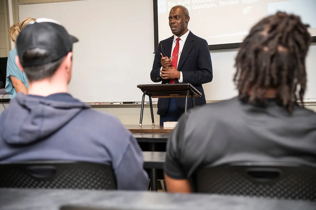A business professor gives a lecture to a class of students.