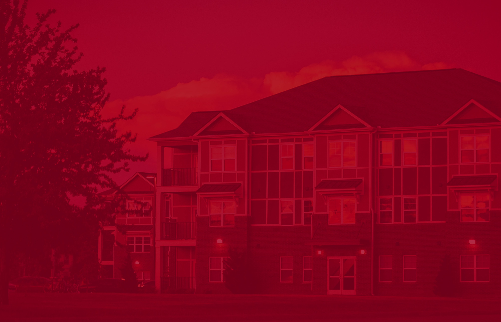 Pack Place apartment building with large windows and balconies, shown with a red color overlay for a stylized effect.