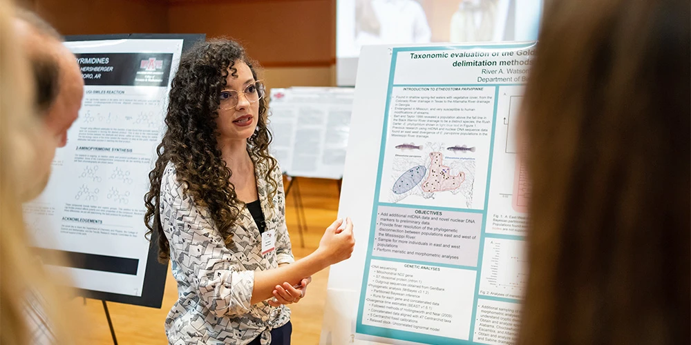 student giving a poster presentation