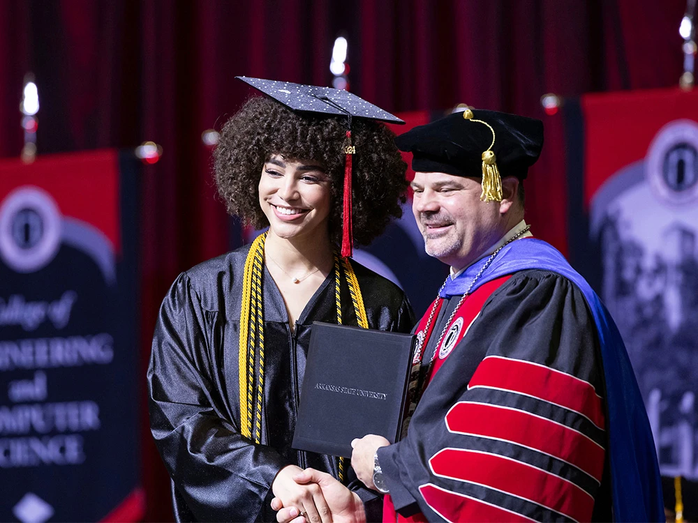 chancellor shaking hands with graduate