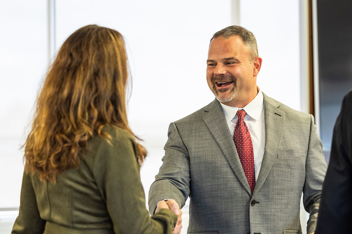 Chancellor Shields gives a handshake during a formal Arkansas State event.