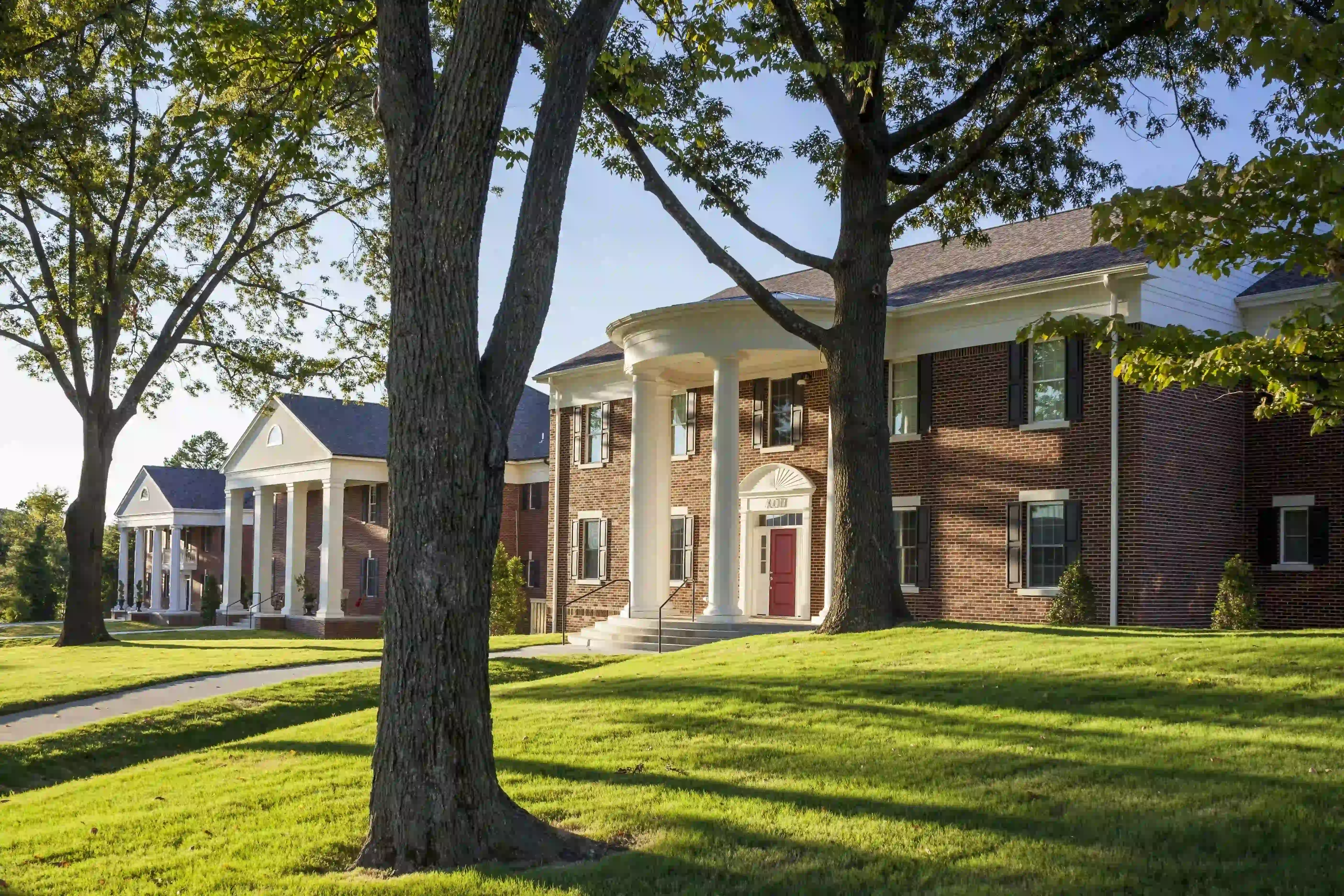 Sorority houses on the campus of Arkansas State University during the day.