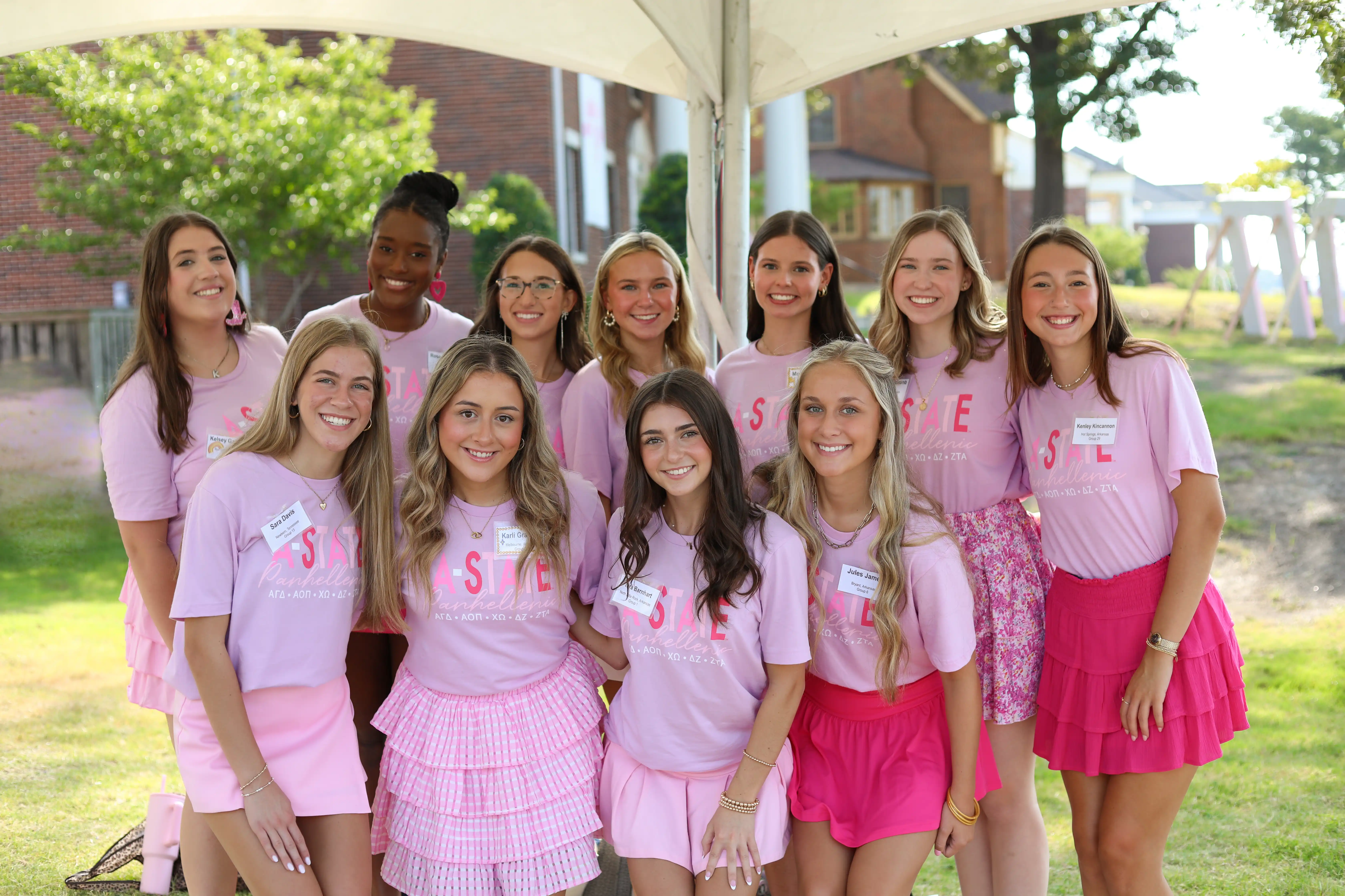 Group of individuals wearing matching shirts posing together outside during recruitment.