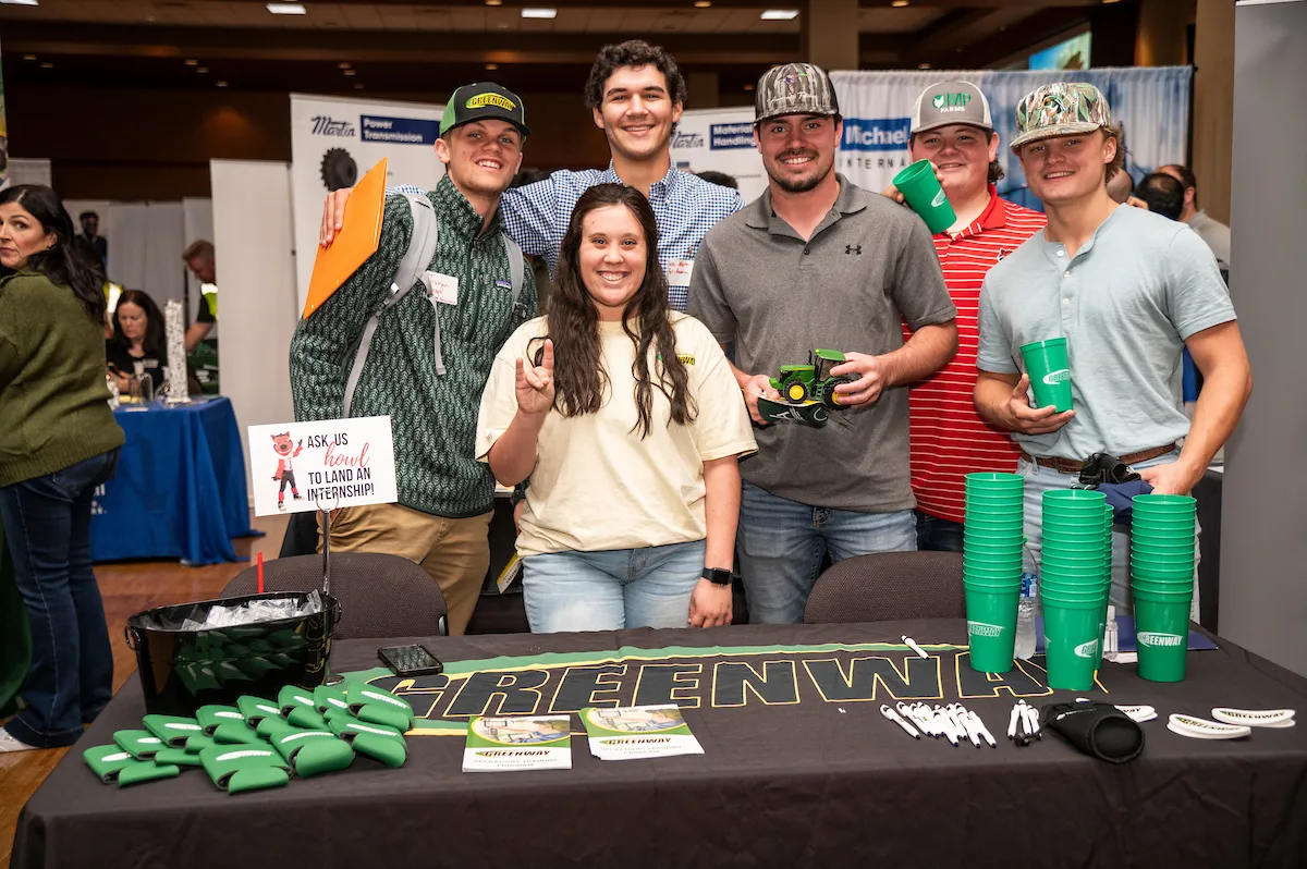 Representatives from Greenway Equipment pose with students at a career fair
