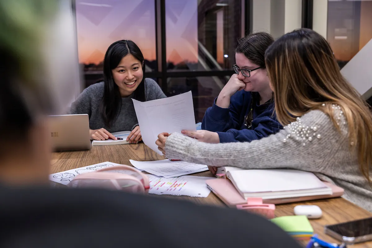 A group of students smiling as they study together.