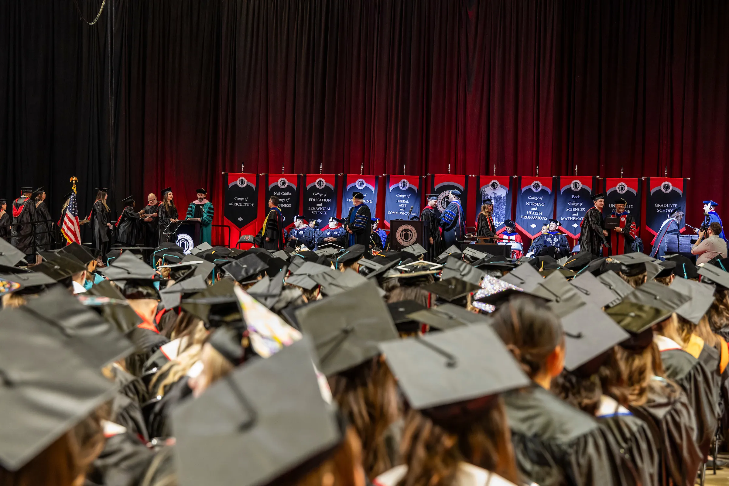 Students from all colleges wait to walk across the stage at commencement