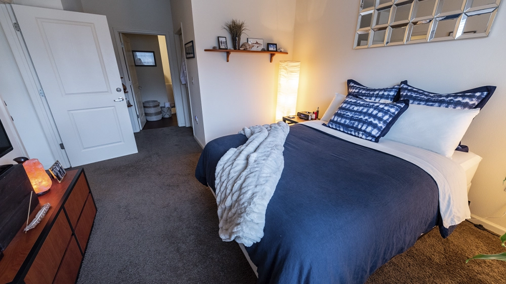 Bedroom with full-size bed, soft bedding, and view toward hallway and bathroom.
