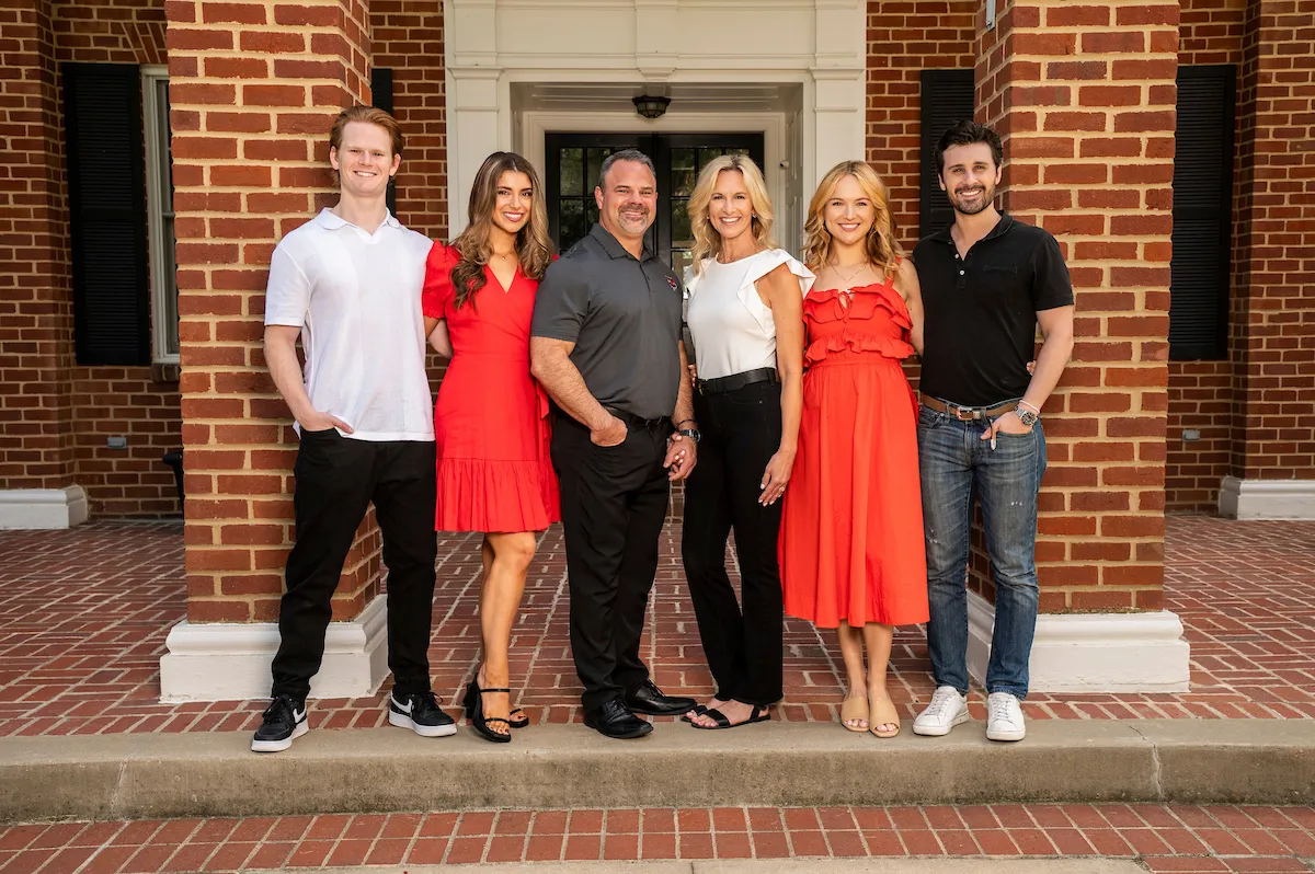 Dr. Todd Shields poses with his family in front of the Chancellor's Residence
