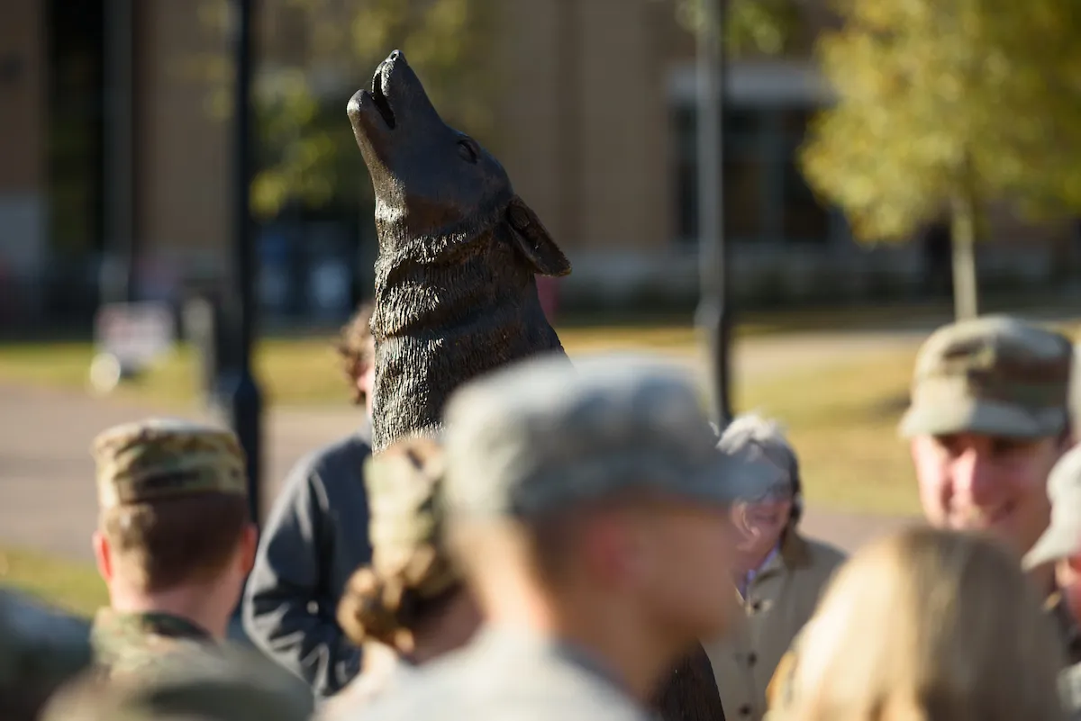 Veterans gather around the tiago statue on campus