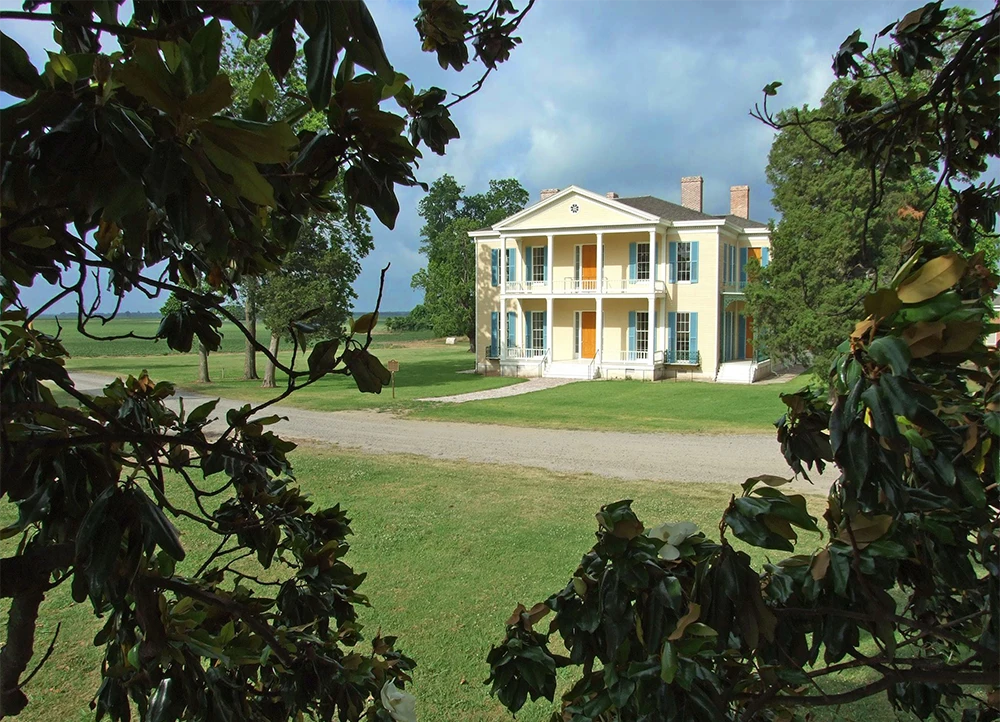 The Lakeport Plantation house framed by leaves.