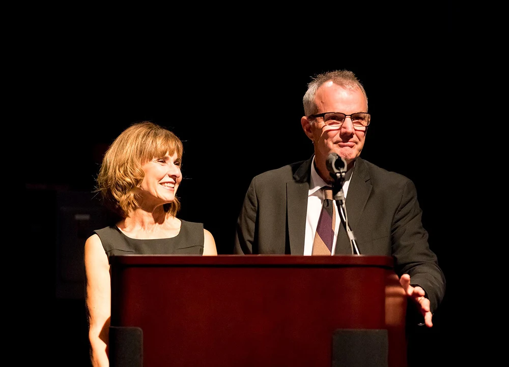 Bob and Molly Simpson speaking at a podium.