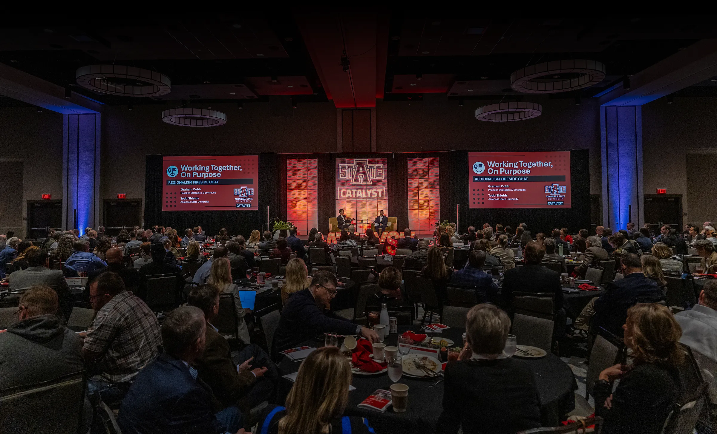A room full of attendees listen to a fireside chat on regionalism.